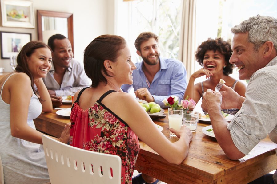 Friends sitting at a table talking during a dinner party